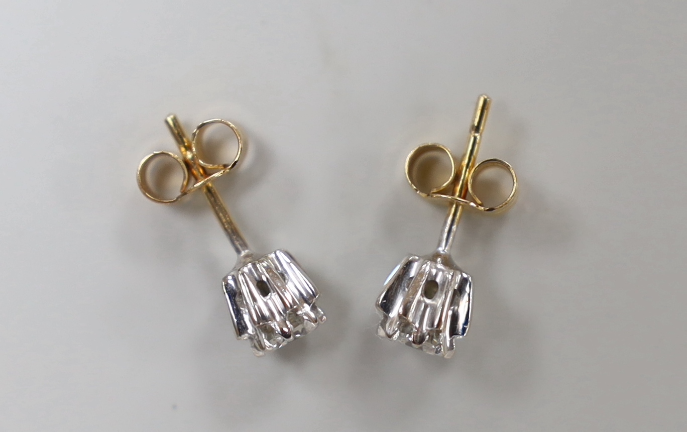 A pair of yellow metal and solitaire diamond set ear studs, gross weight 1.5 grams.